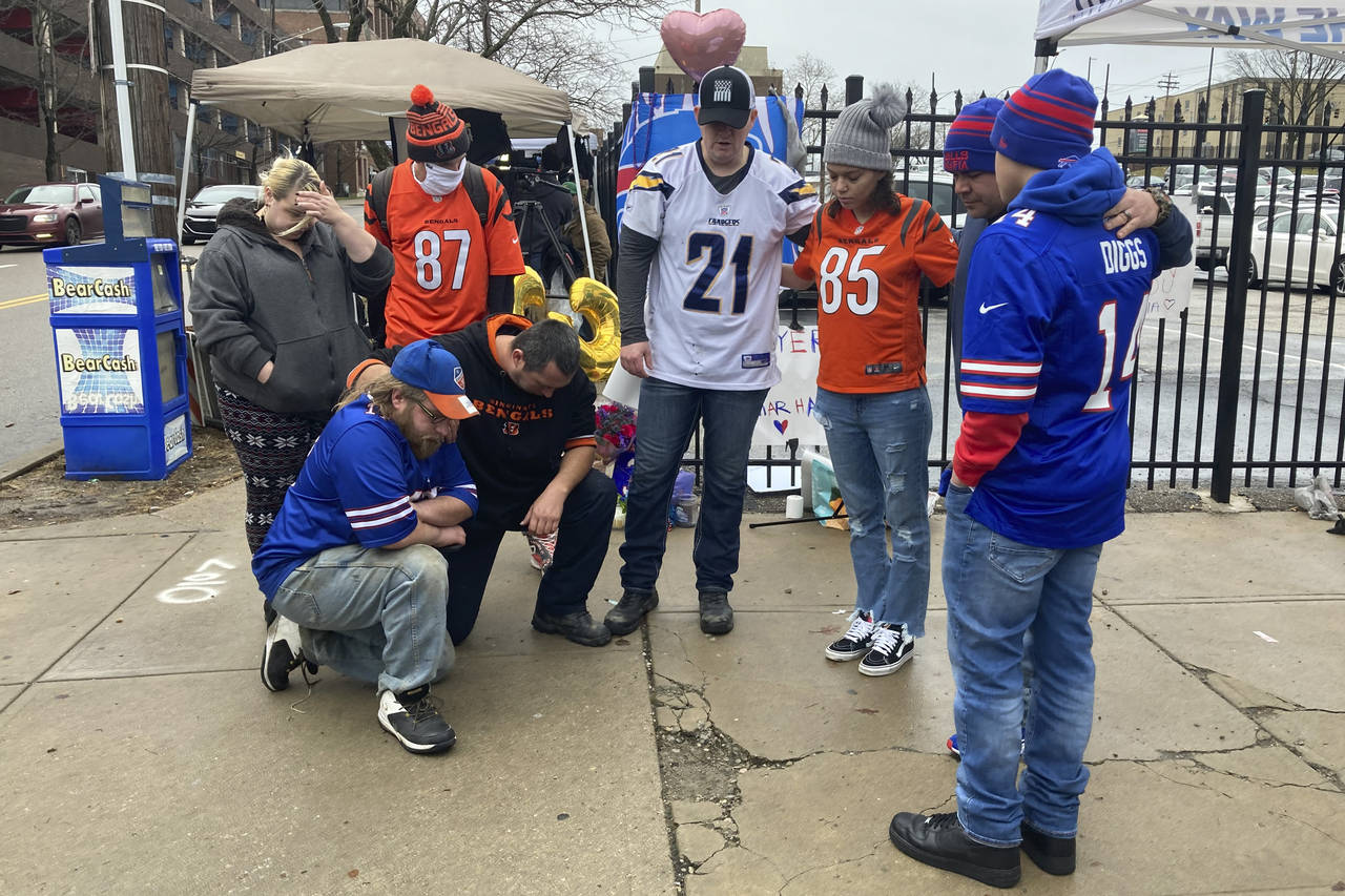 Football fans gather outside of University of Cincinnati Medical Center and pray for Buffalo Bills'...