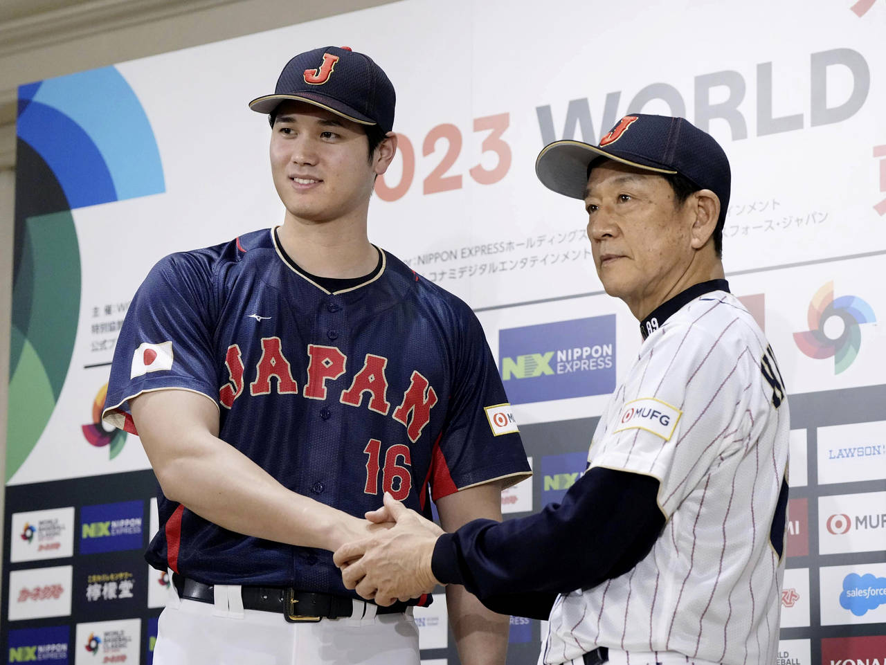 Shohei Ohtani, left, of Los Angeles Angels, shakes hands with Japan's manager Hideki Kuriyama, righ...