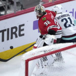 
              Chicago Blackhawks goaltender Alex Stalock (32) and Seattle Kraken's Alex Wennberg vie for the puck behind the net during the second period of an NHL hockey game Saturday, Jan. 14, 2023, in Chicago. (AP Photo/Charles Rex Arbogast)
            