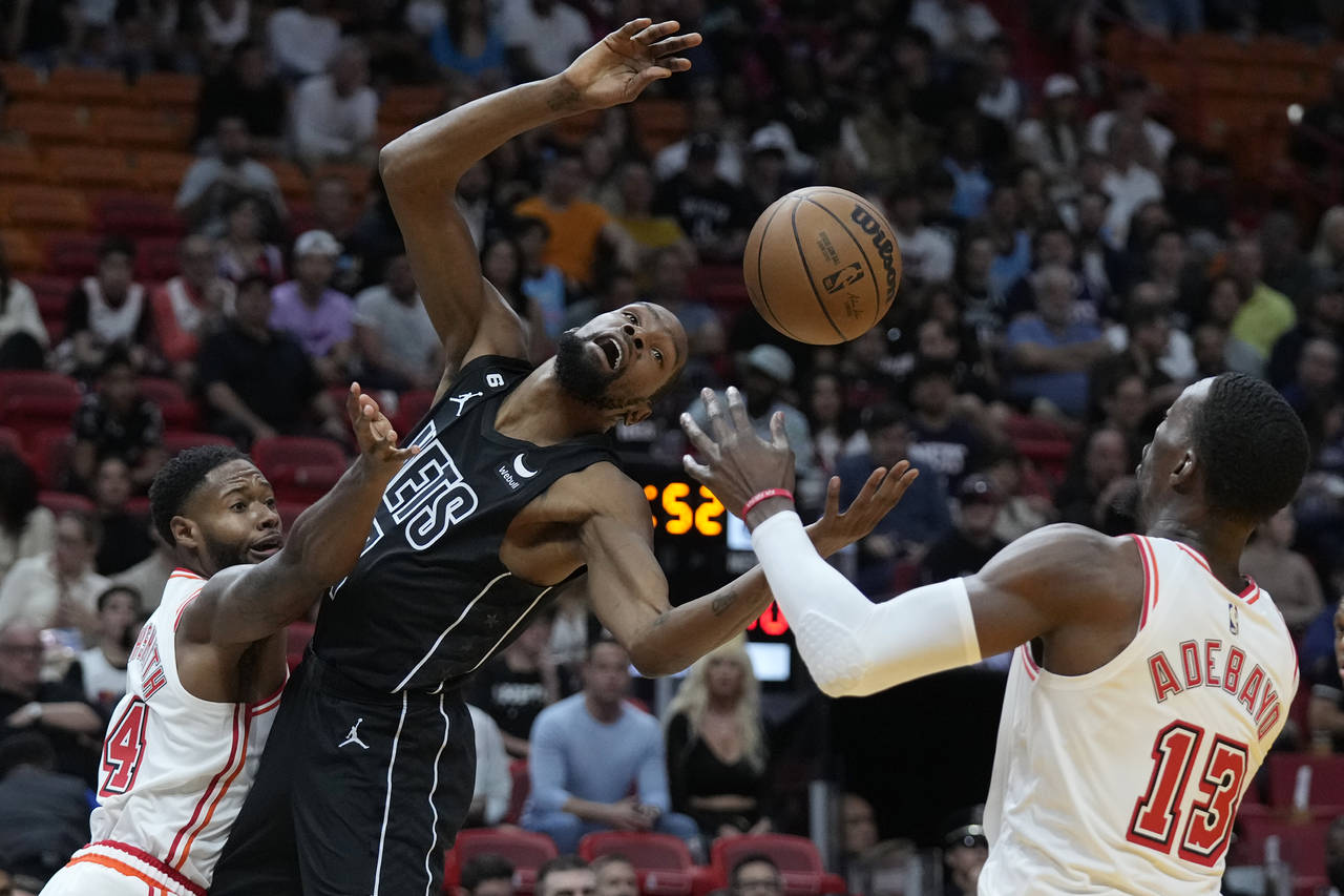 Miami Heat forward Haywood Highsmith, left, swats the ball away from Brooklyn Nets forward Kevin Du...