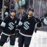 
              Seattle Kraken right wing Oliver Bjorkstrand (22) leads defenseman Adam Larsson (6) and center Yanni Gourde (37) after scoring against the Vancouver Canucks during the second period of an NHL hockey game Wednesday, Jan. 25, 2023, in Seattle. (AP Photo/John Froschauer)
            