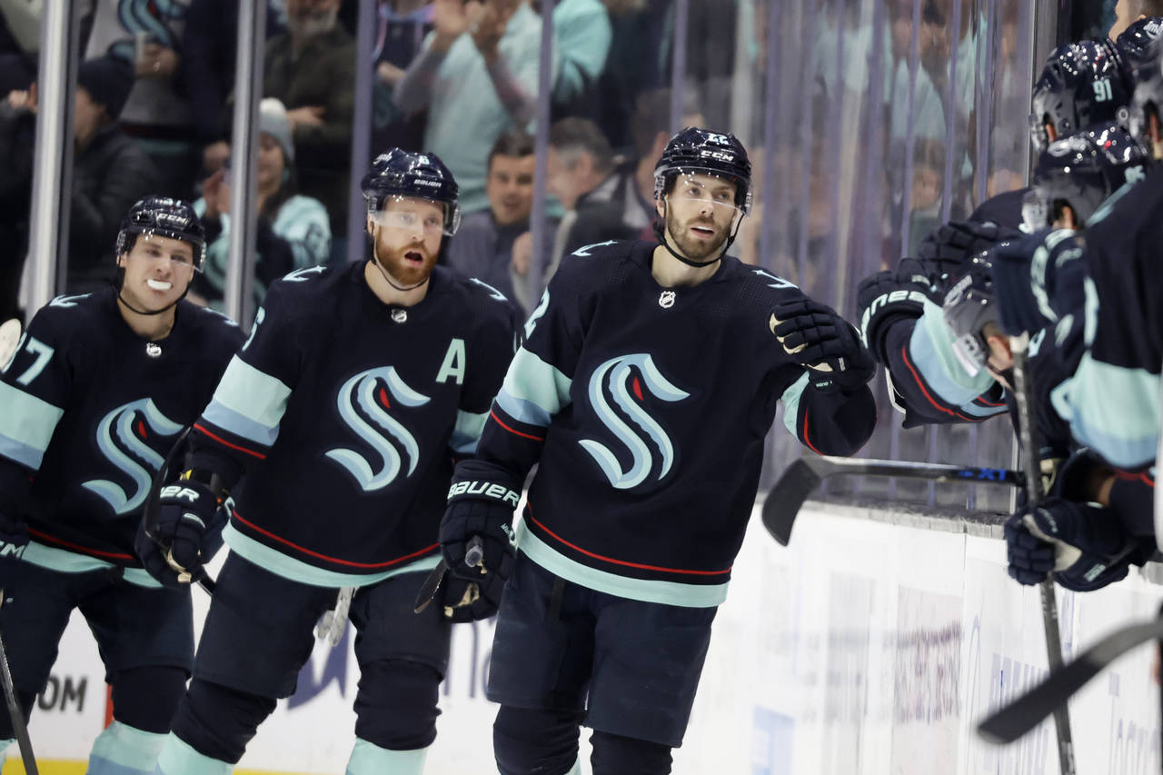 Seattle Kraken right wing Oliver Bjorkstrand (22) leads defenseman Adam Larsson (6) and center Yann...