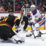 Oilers beat reeling Canucks 4-2 for 6th straight victory.