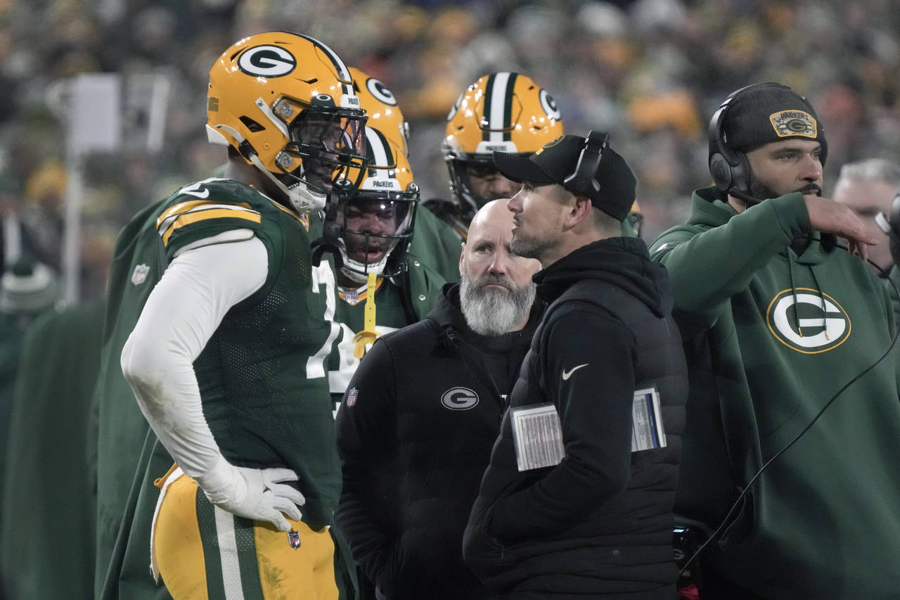 Green Bay Packers head coach Matt LaFleur talks to linebacker Quay Walker, left, after Walker was e...