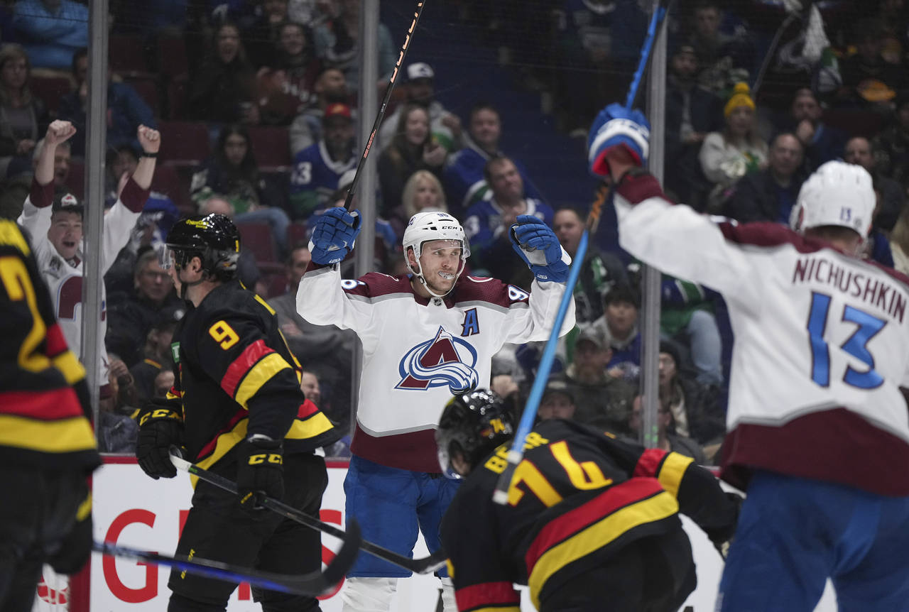 Colorado Avalanche's Mikko Rantanen, back, celebrates his goal against the Vancouver Canucks during...