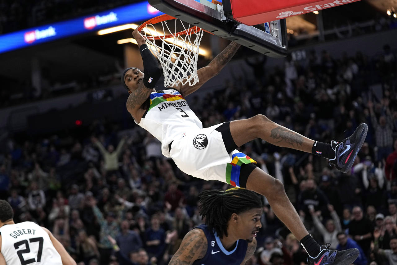 Minnesota Timberwolves forward Jaden McDaniels (3) dunks against Memphis Grizzlies guard Ja Morant ...
