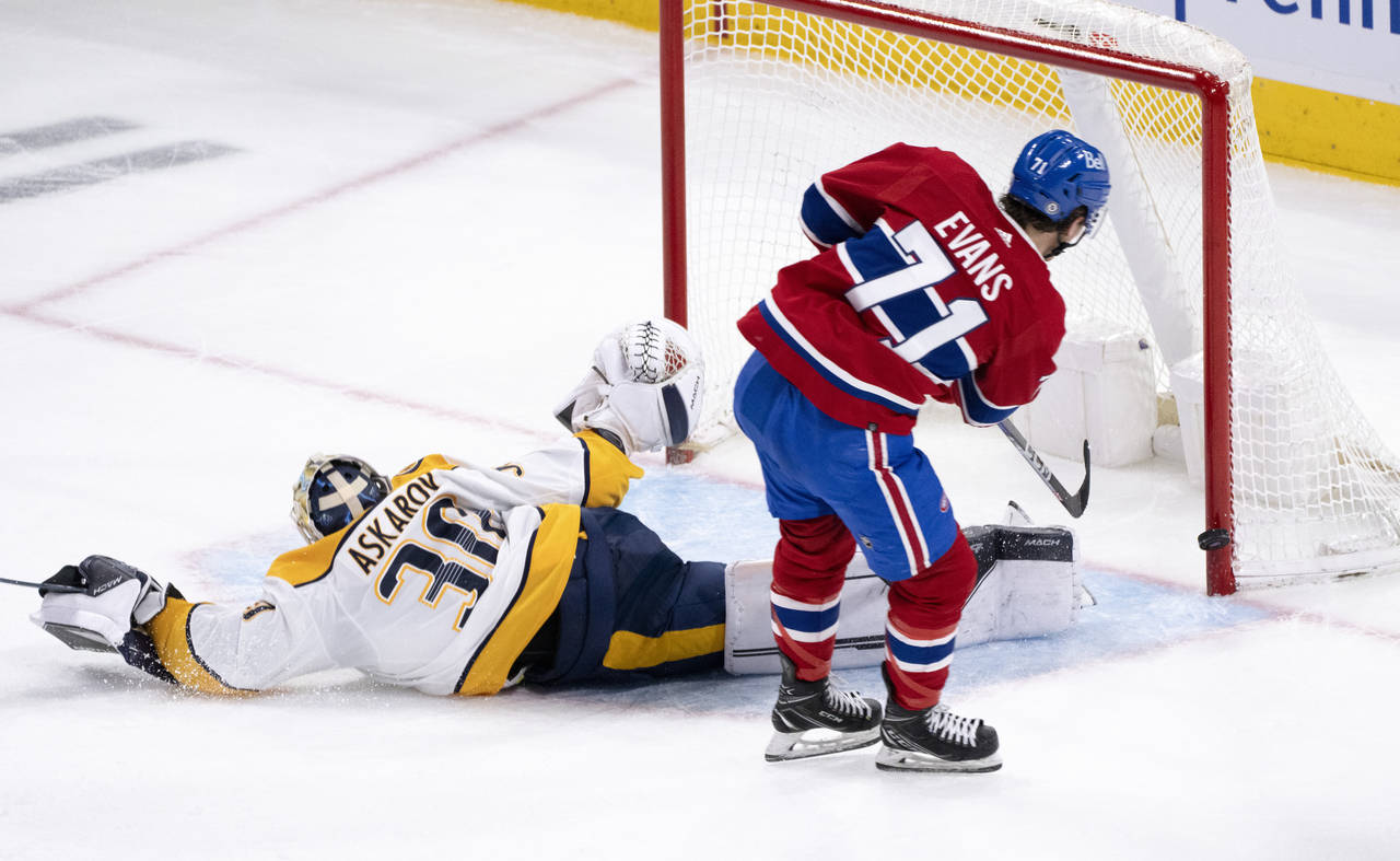 Montreal Canadiens' Jake Evans, right, hits the goalpost behind Nashville Predators goaltender Yaro...