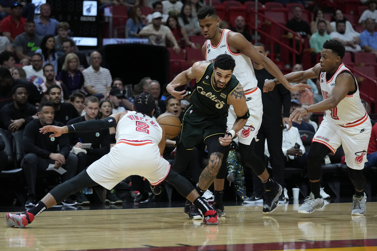 Boston Celtics forward Jayson Tatum (0) loses control of the ball against Miami Heat guard Gabe Vin...