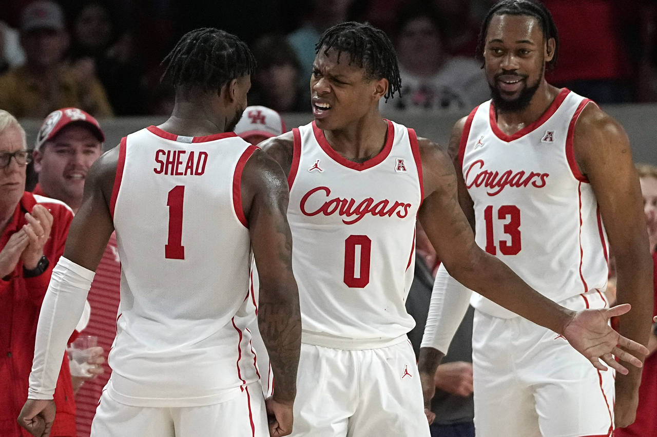 Houston's Marcus Sasser (0) celebrates with Jamal Shead (1) after making a basket while being foule...