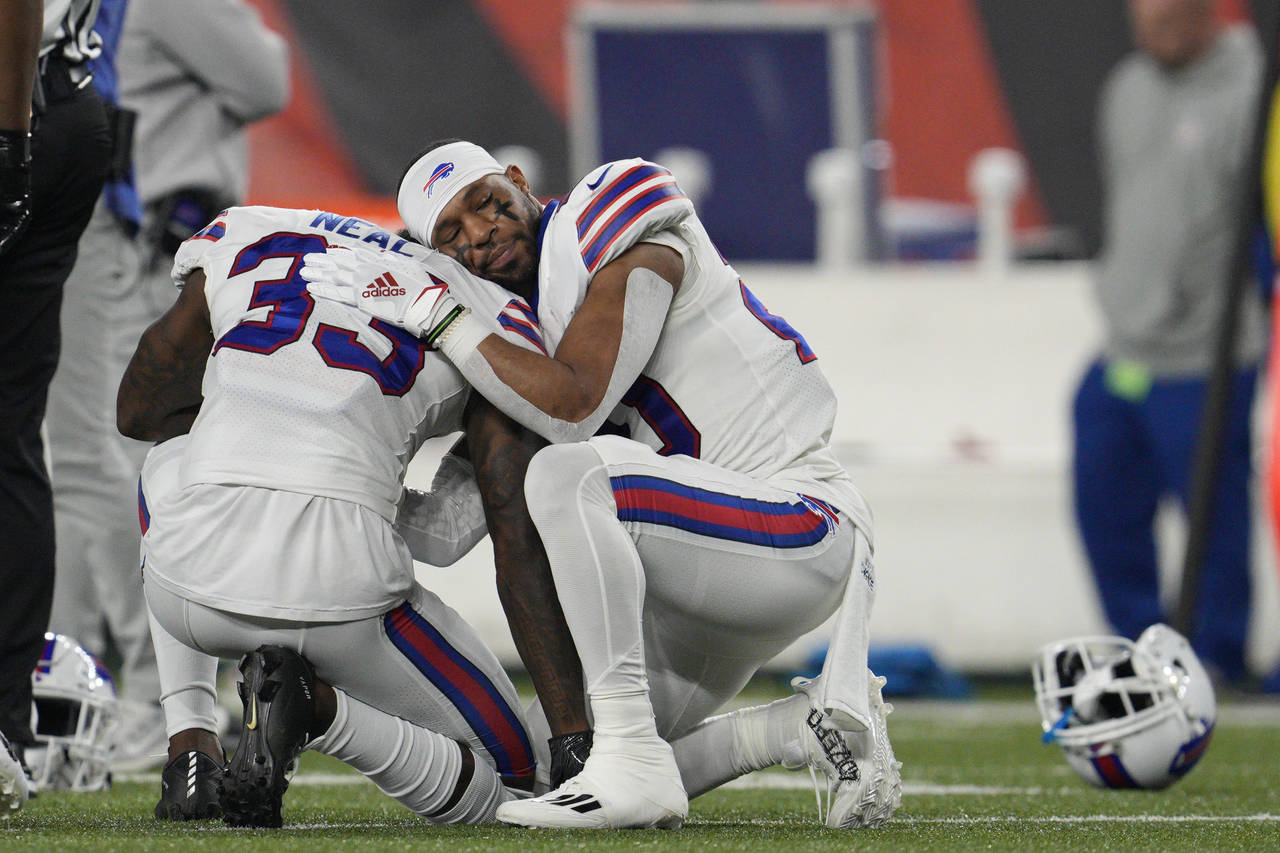 Buffalo Bills' Siran Neal (33) and Nyheim Hines react after teammate Damar Hamlin was injured durin...