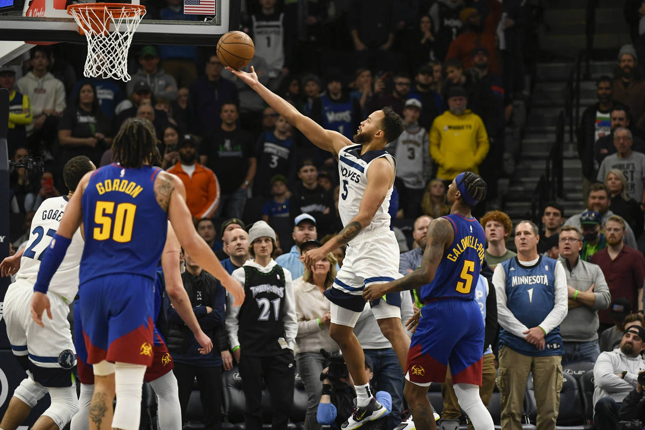 Minnesota Timberwolves forward Kyle Anderson (5) goes up to shoot past Denver Nuggets guard Kentavi...