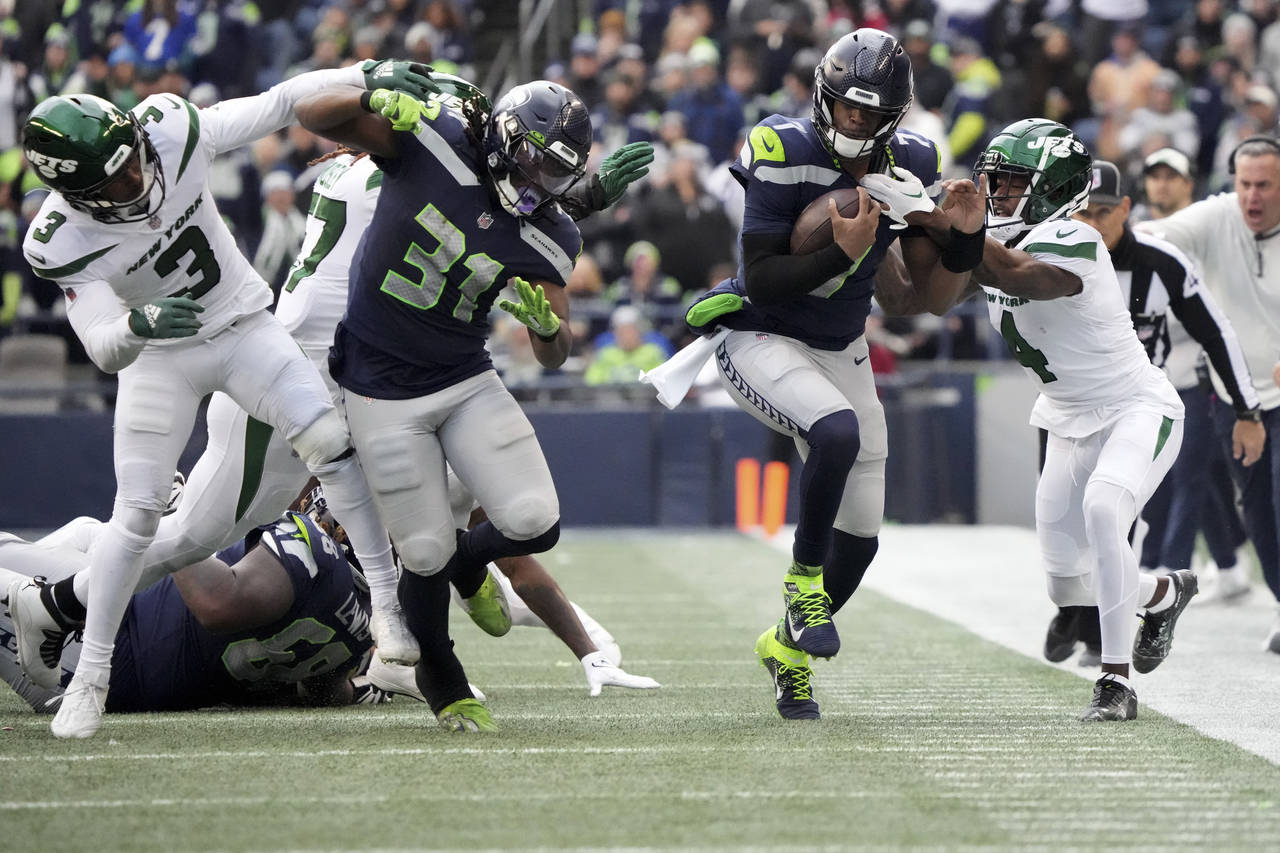 Seattle Seahawks quarterback Geno Smith runs for a first down as New York Jets cornerback D.J. Reed...
