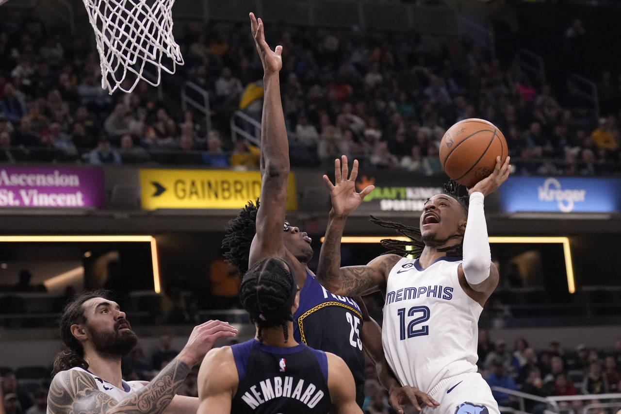 Memphis Grizzlies guard Ja Morant (12) shoots around Indiana Pacers forward Jalen Smith (25) during...