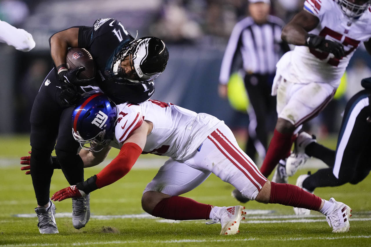 Philadelphia Eagles running back Kenneth Gainwell (14) takes a hit from New York Giants linebacker ...