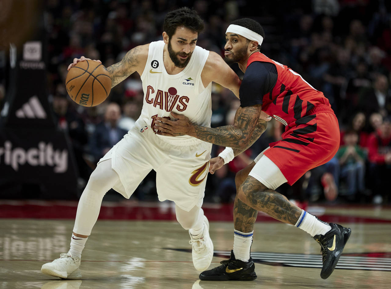 Cleveland Cavaliers guard Ricky Rubio, left, dribbles around Portland Trail Blazers guard Gary Payt...