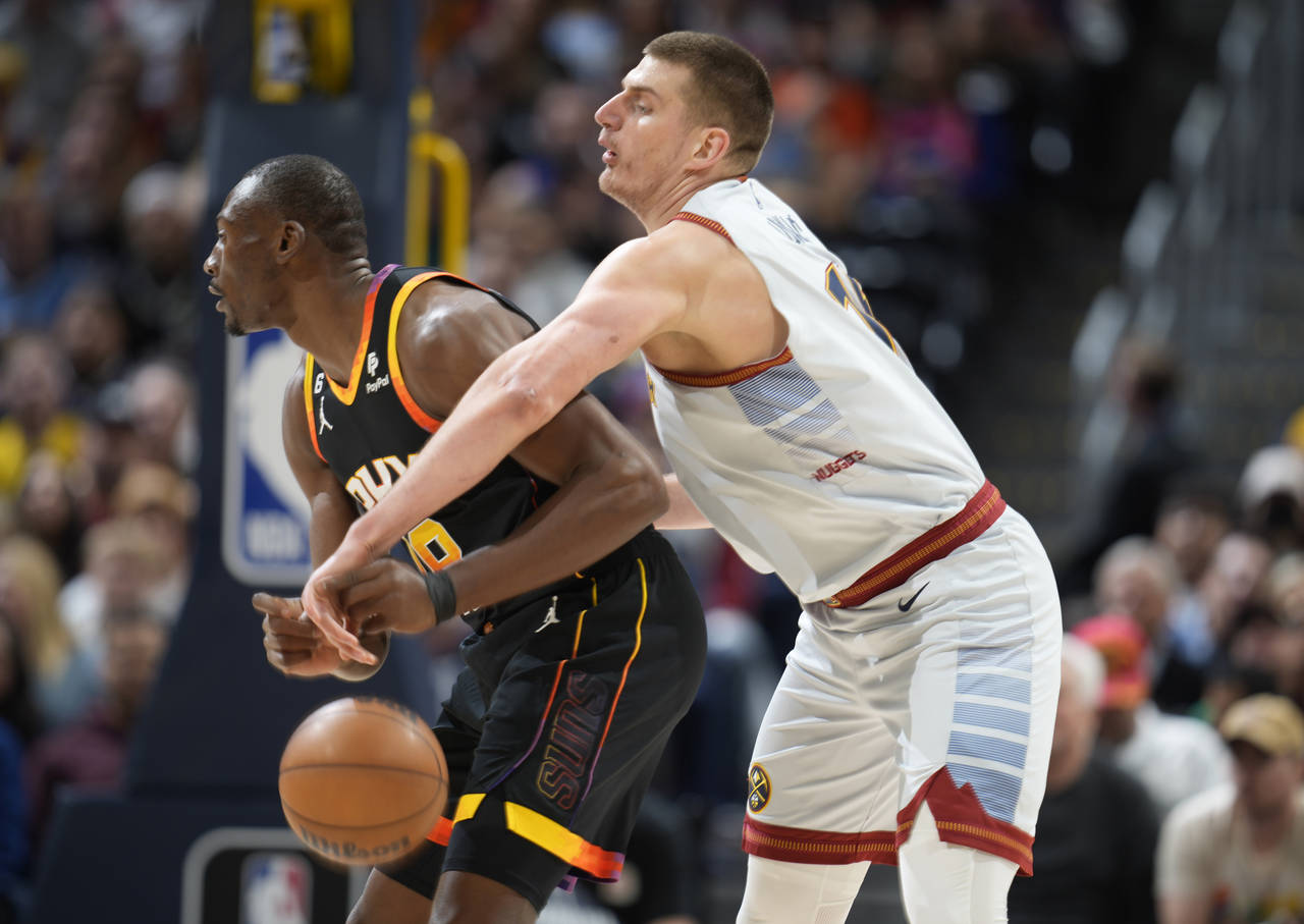 Denver Nuggets center Nikola Jokic, right, knocks the ball away from Phoenix Suns center Bismack Bi...