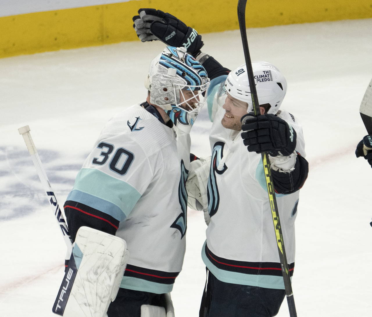 Seattle Kraken goaltender Martin Jones (30) celebrates with teammate Daniel Sprong (91) after shutt...