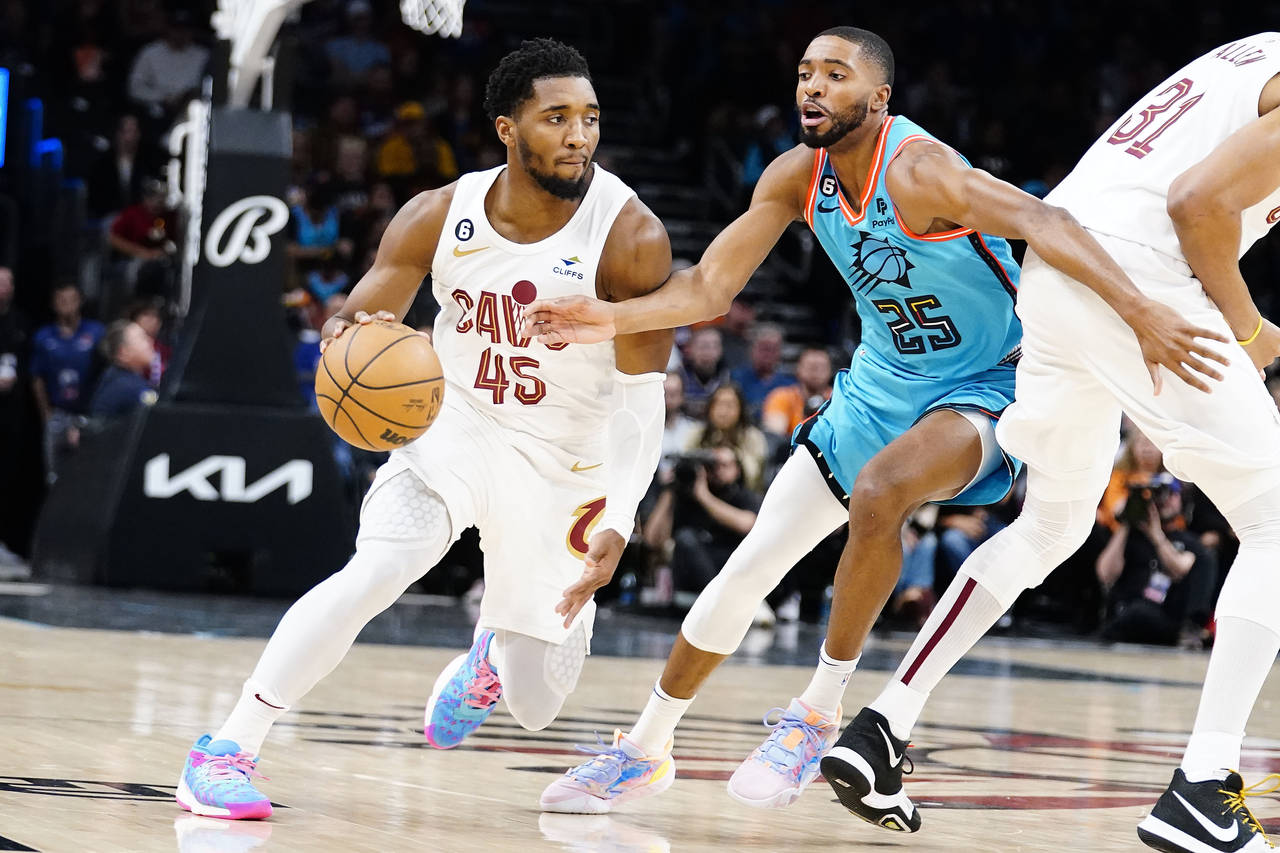 Cleveland Cavaliers' Donovan Mitchell (45) drives around Phoenix Suns' Mikel Bridges (25) during th...