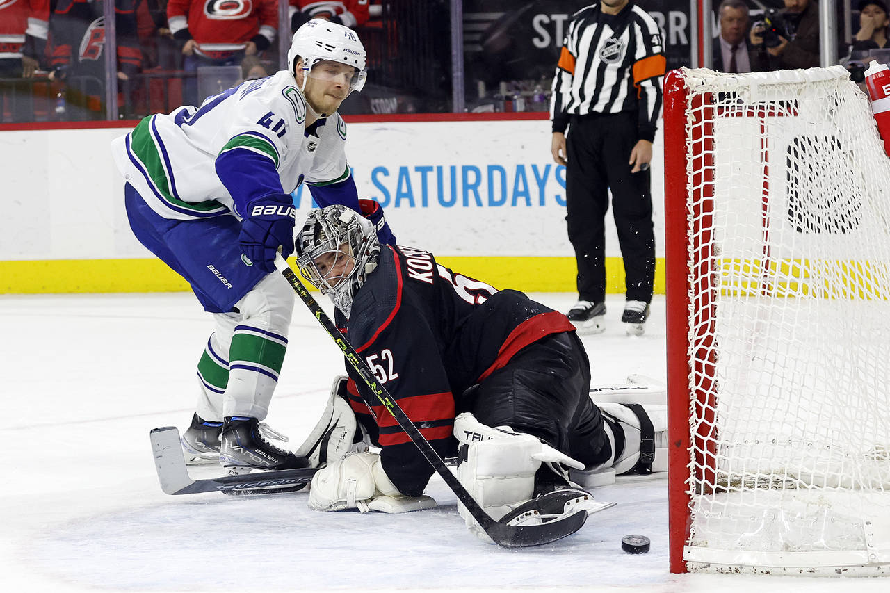 Vancouver Canucks' Elias Pettersson (40) slips the puck past Carolina Hurricanes goaltender Pyotr K...