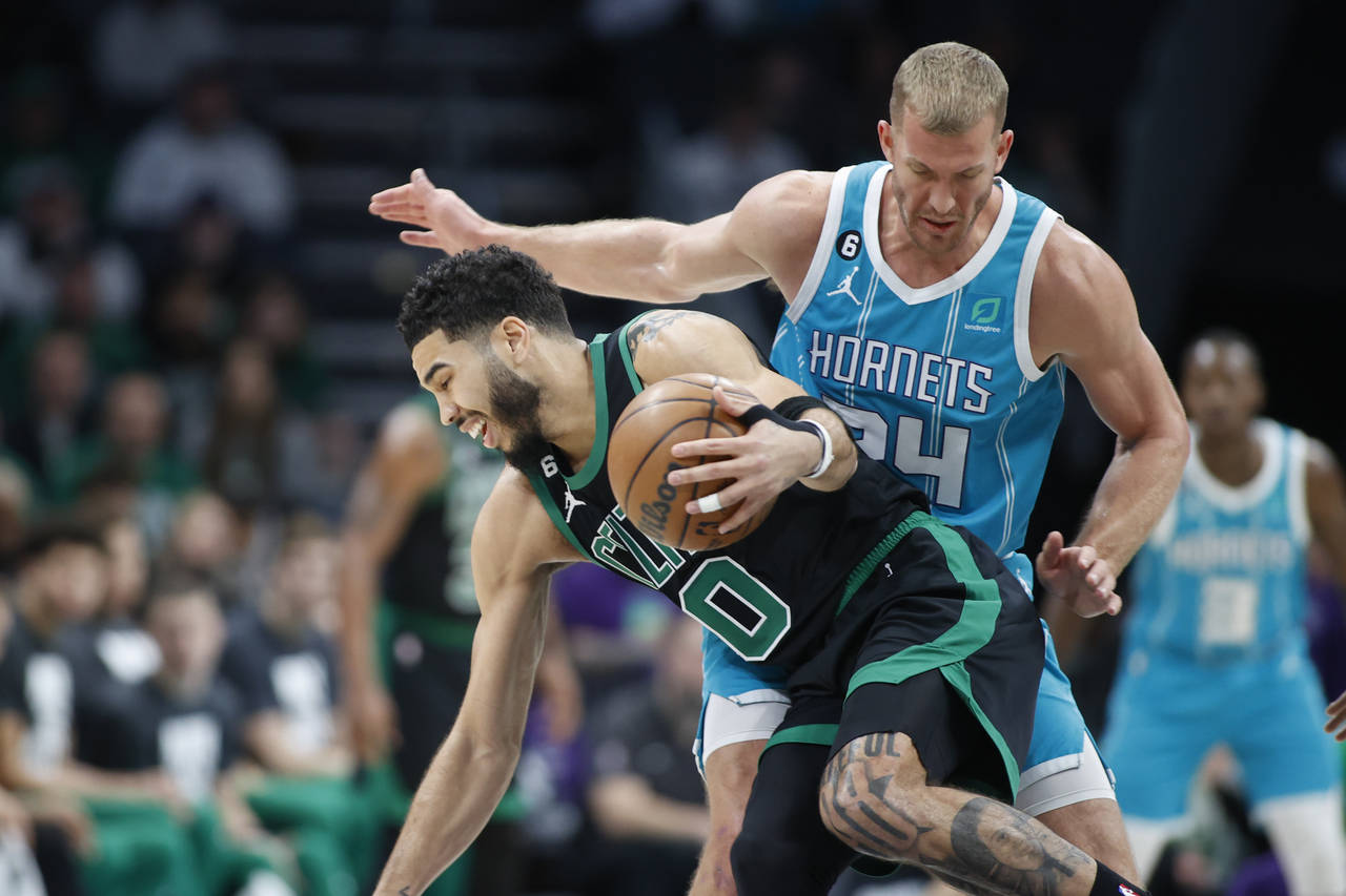 Boston Celtics forward Jayson Tatum (0) drives around Charlotte Hornets center Mason Plumlee during...