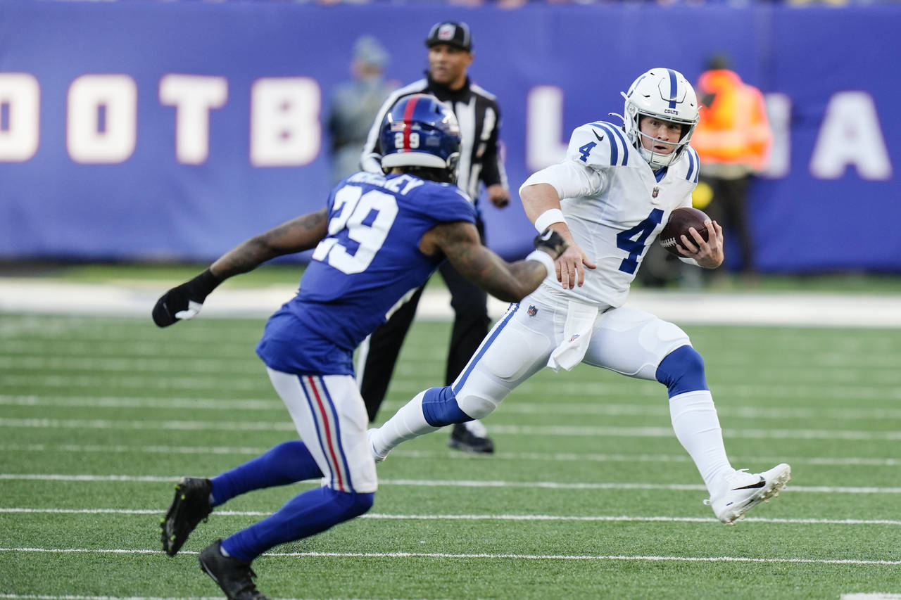 Indianapolis Colts quarterback Sam Ehlinger (4) runs away from New York Giants' Xavier McKinney (29...