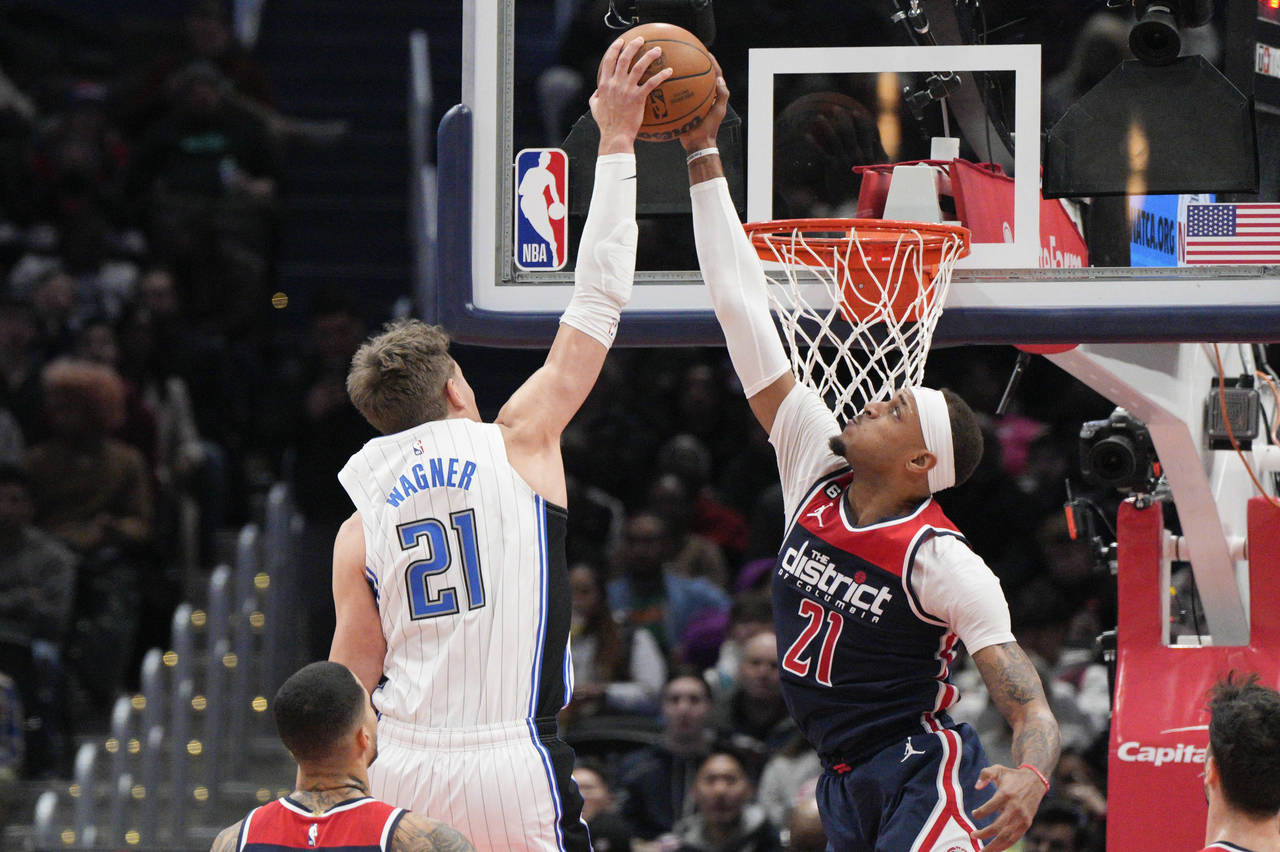 Orlando Magic center Moritz Wagner, left, shoots as Washington Wizards center Daniel Gafford, right...