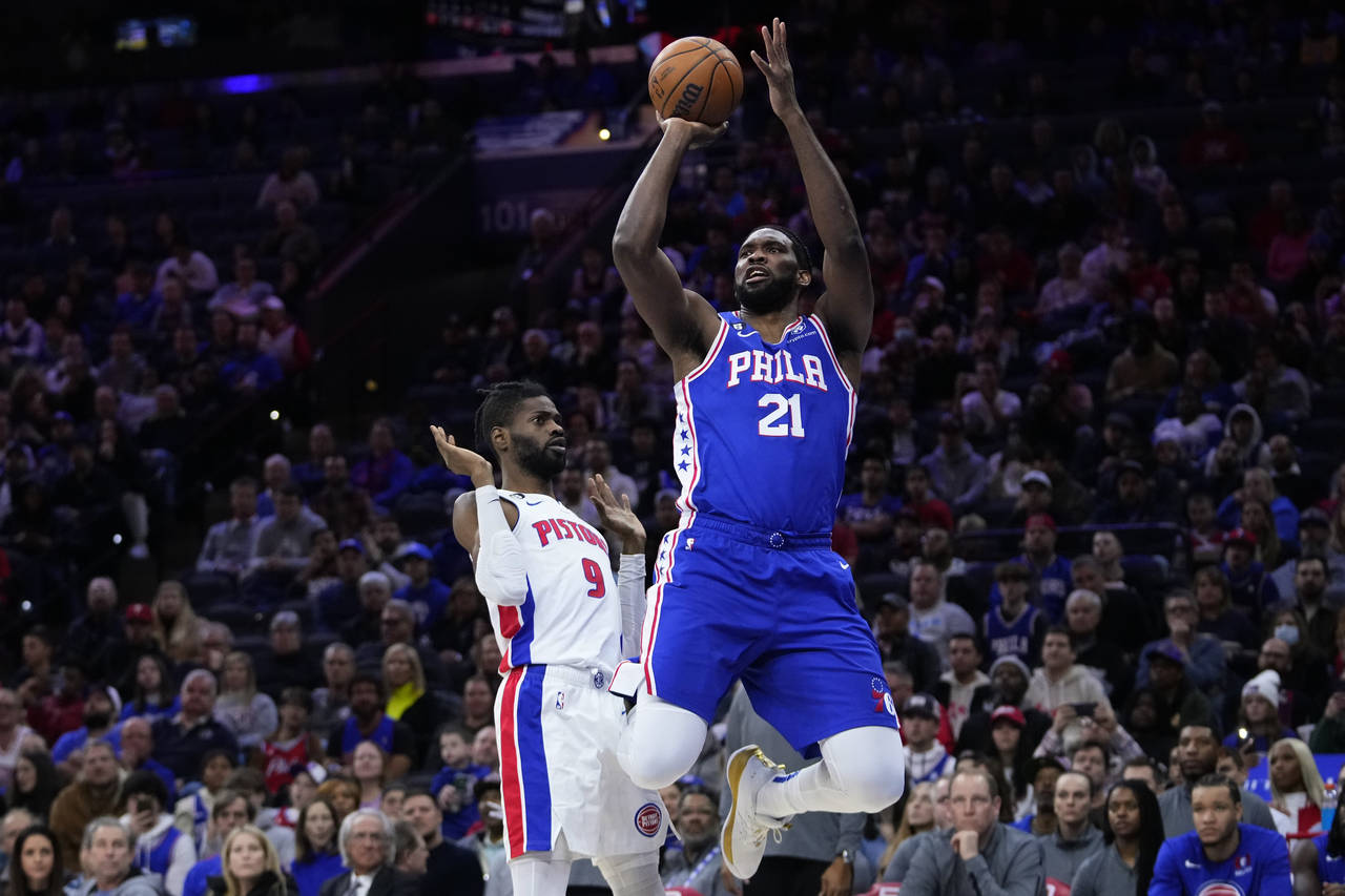 Philadelphia 76ers' Joel Embiid, right, goes up for a shot past Detroit Pistons' Nerlens Noel durin...