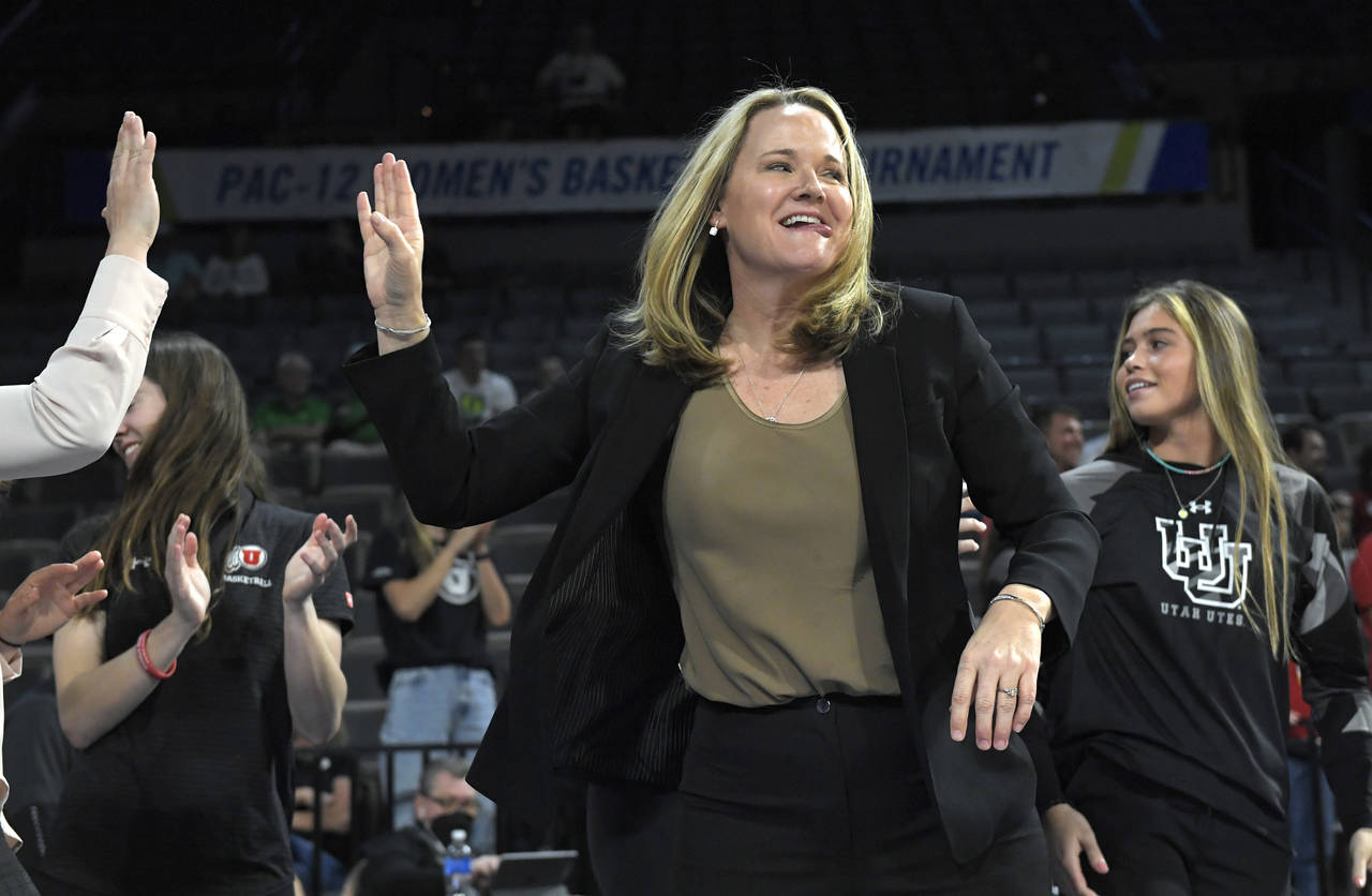 FILE - Utah head coach Lynne Roberts high-fives players on the bench after the team's victory over ...