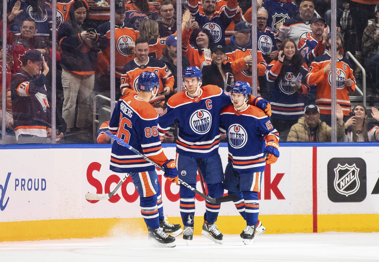 Edmonton Oilers' Philip Broberg (86), Connor McDavid (97) and Kailer Yamamoto (56) celebrate after ...
