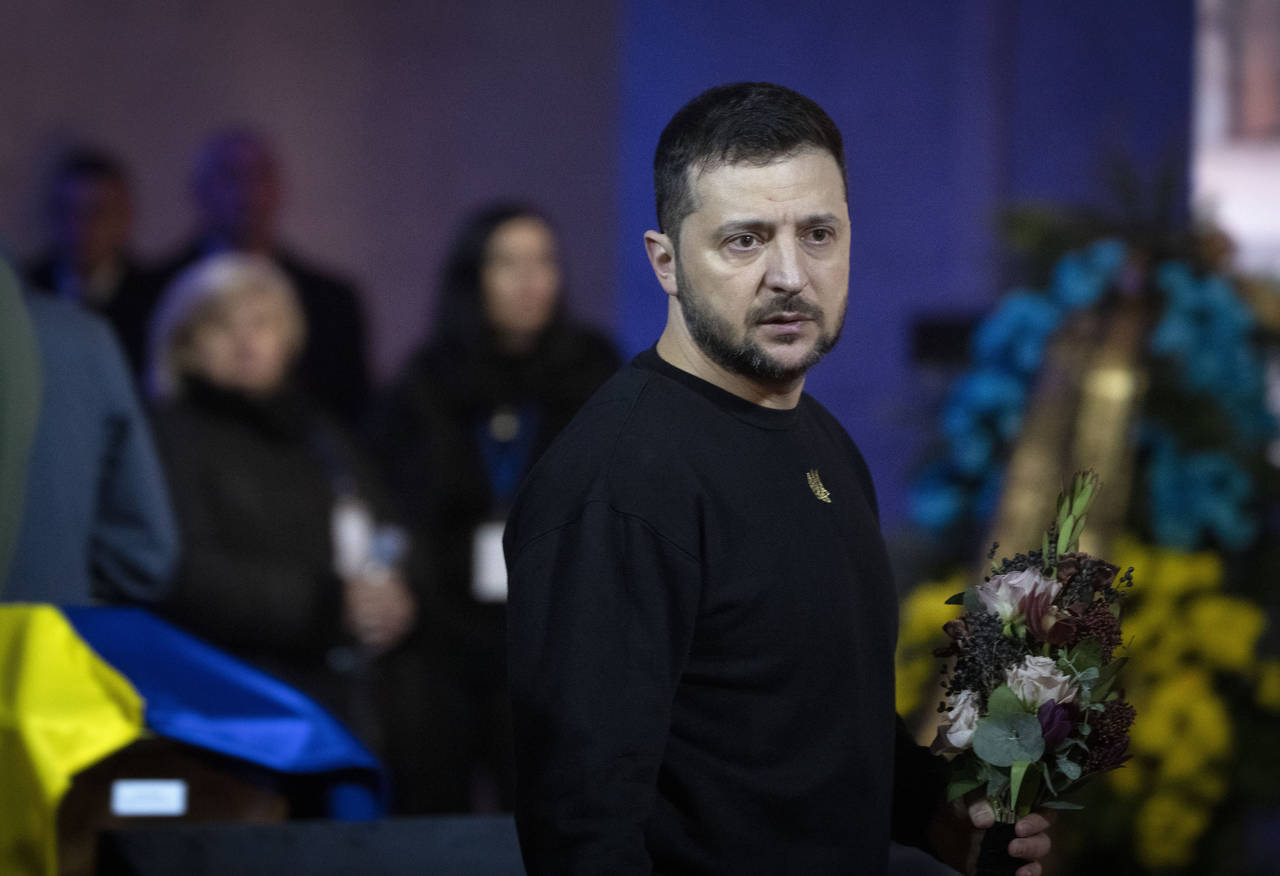 Ukrainian President Volodymyr Zelenskyy pays his respects to victims of a deadly helicopter crash d...