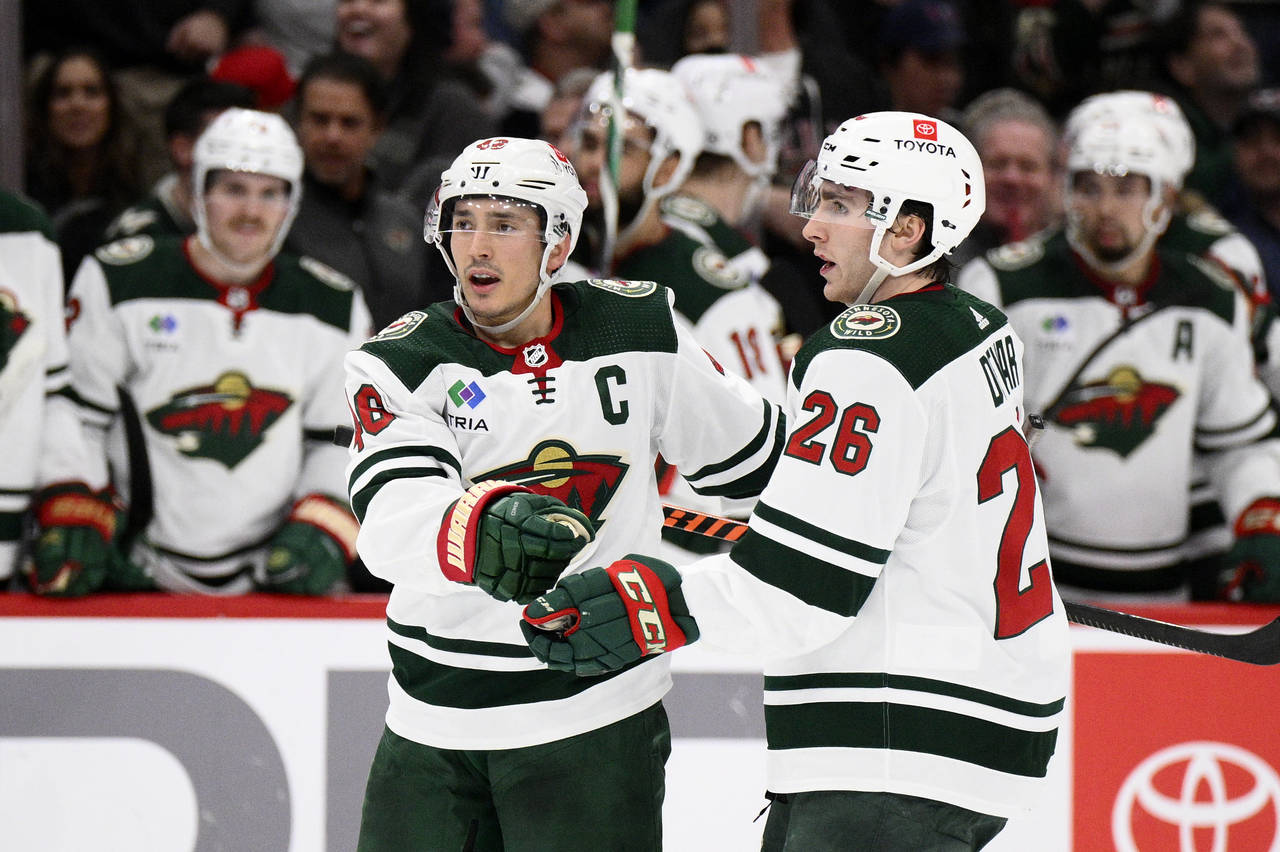 Minnesota Wild defenseman Jared Spurgeon, left, celebrates his goal with center Connor Dewar (26) d...
