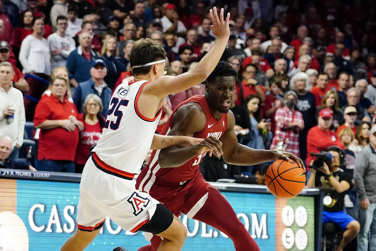 Washington State's TJ Bamba, right, drives around Arizona's Kerr Kriisa (25) during the first half ...