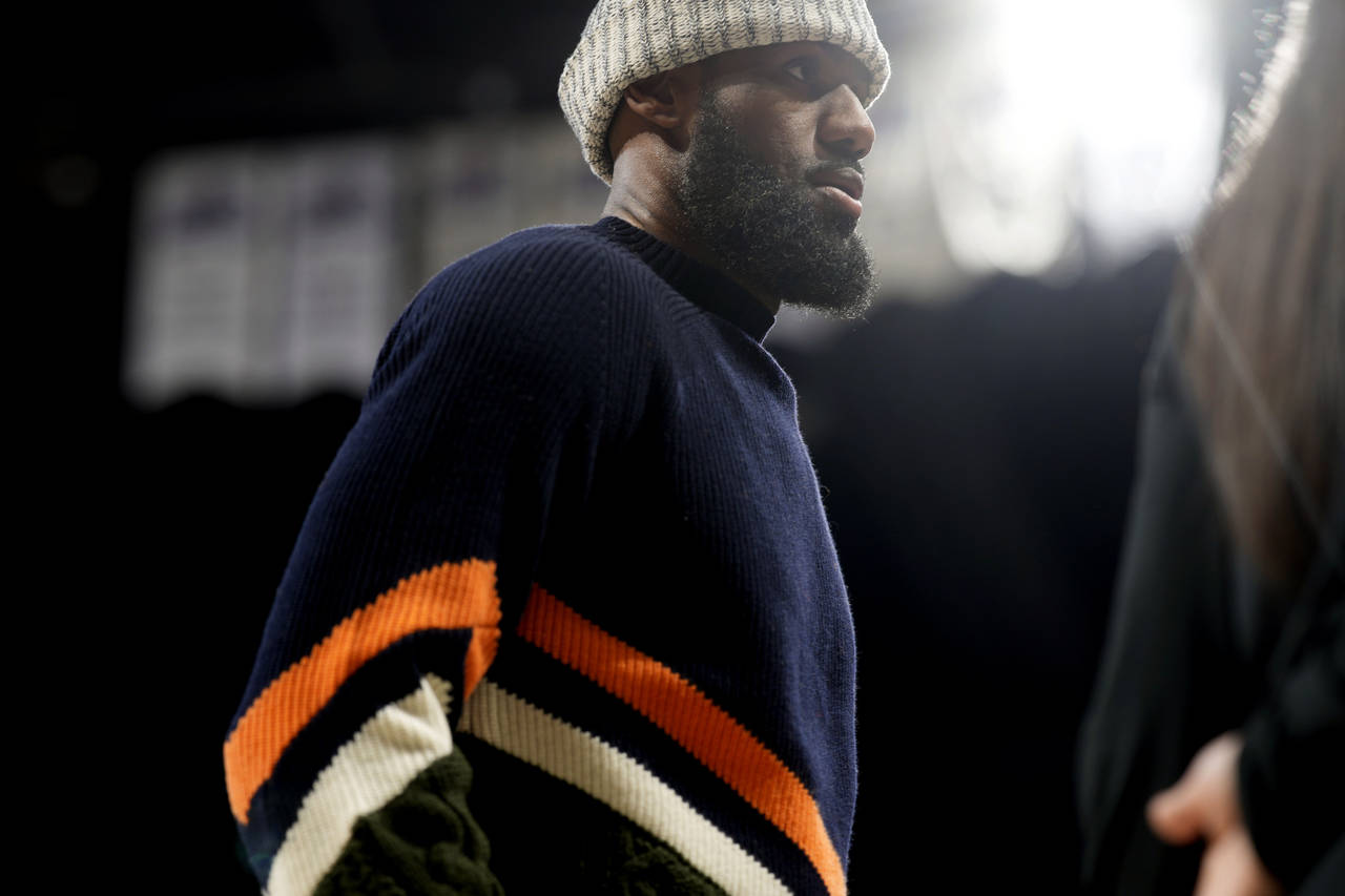 Sidelined for the game by ankle soreness, Los Angeles Lakers forward LeBron James heads to the benc...