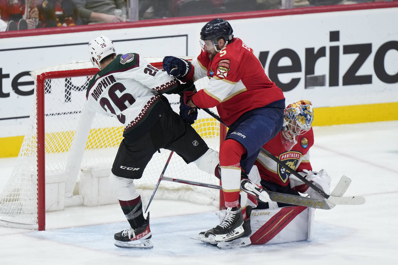 Florida Panthers defenseman Aaron Ekblad (5) pushes Arizona Coyotes center Laurent Dauphin (26) out...