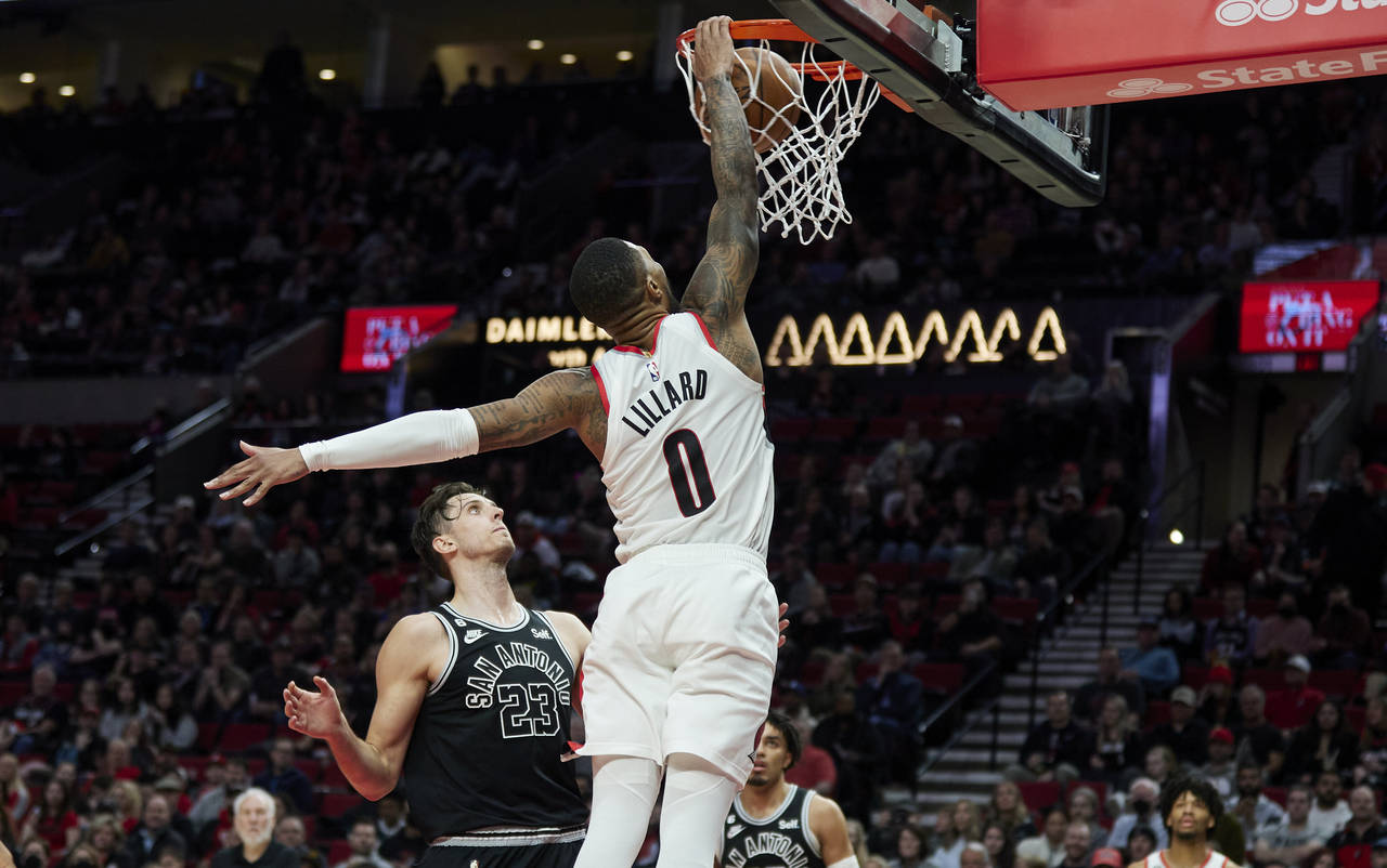 Portland Trail Blazers guard Damian Lillard (0) dunks over San Antonio Spurs forward Zach Collins (...