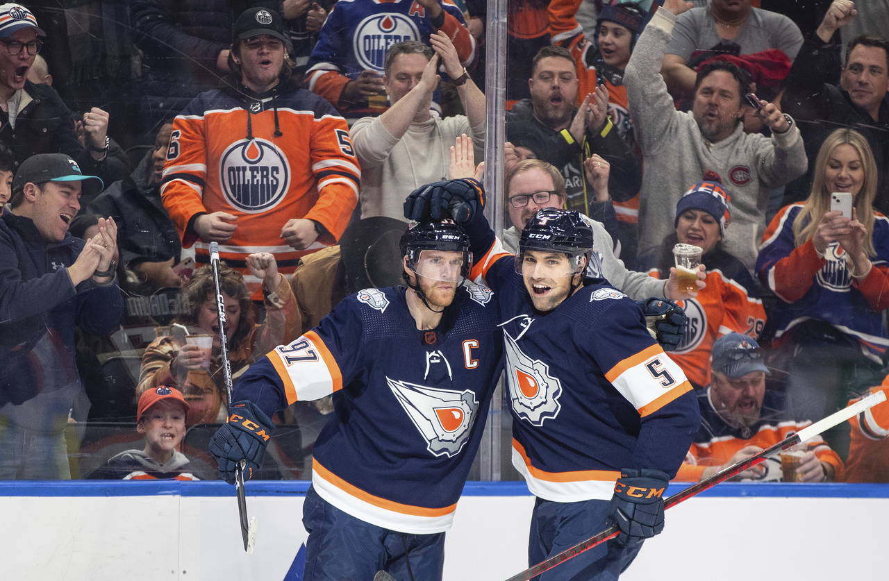 Edmonton Oilers' Connor McDavid (97) and Cody Ceci (5) celebrate a goal against the Chicago Blackha...