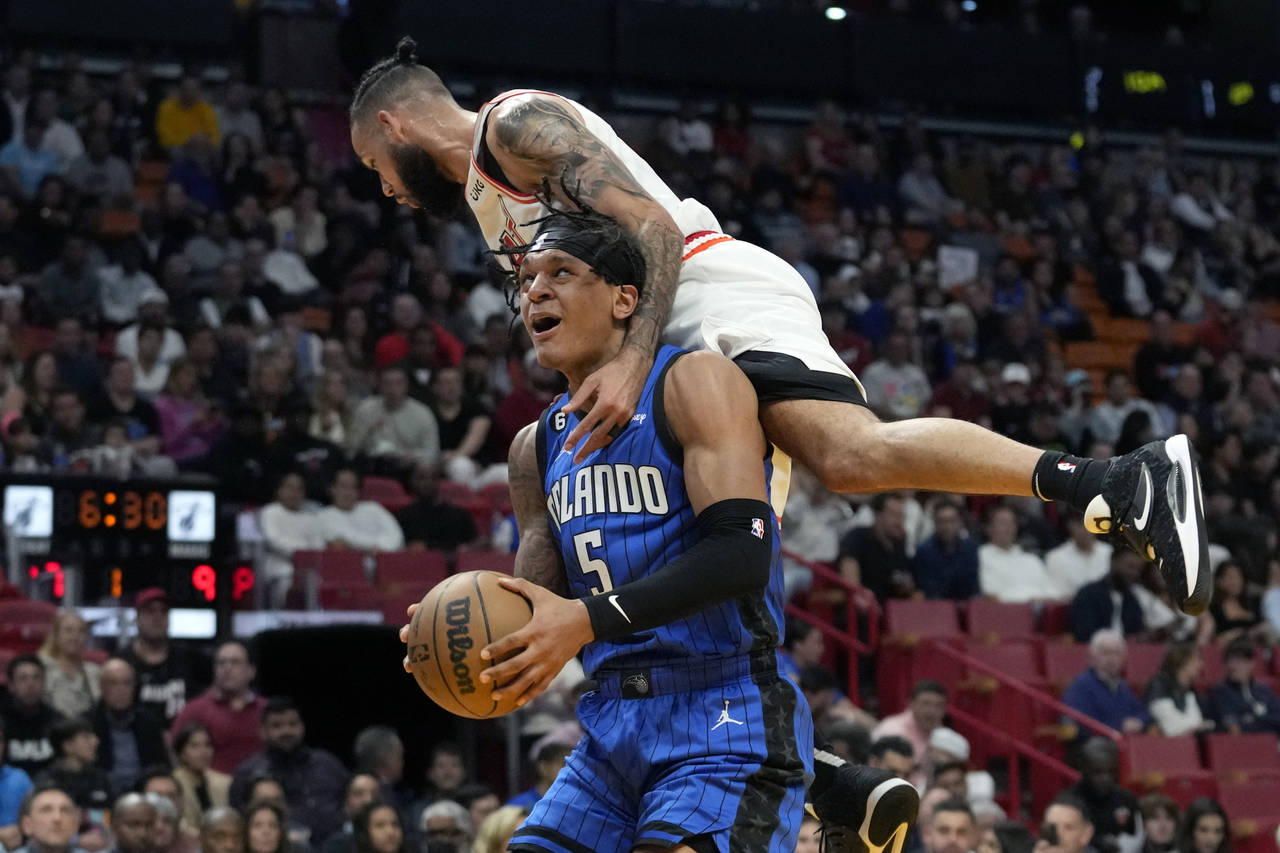 Orlando Magic forward Paolo Banchero (5) is fouled by Miami Heat forward Caleb Martin during the fi...