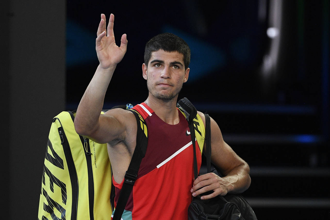 FILE- Carlos Alcaraz of Spain waves as he leaves Rod Laver Arena following his third round loss to ...