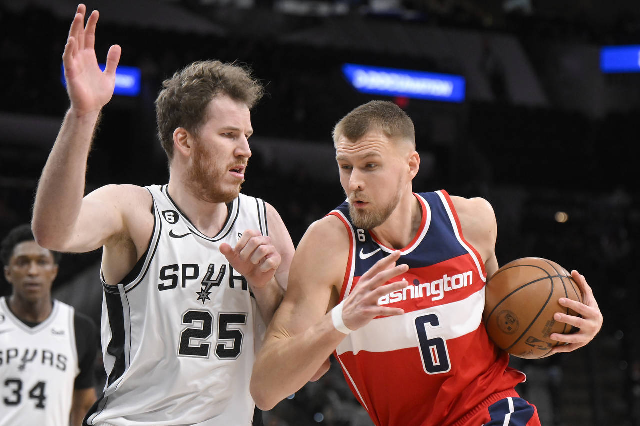 Washington Wizards' Kristaps Porzingis (6) drives against San Antonio Spurs' Jakob Poeltl during th...