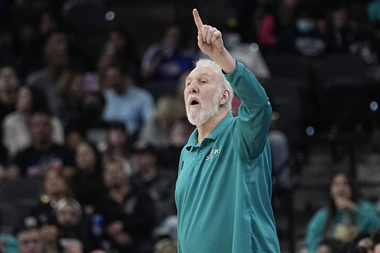 San Antonio Spurs coach Gregg Popovich signals to players during the first half of the team's NBA b...