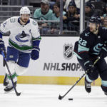 
              Seattle Kraken right wing Oliver Bjorkstrand (22) skates with the puck with Vancouver Canucks defenseman Oliver Ekman-Larsson trailing during the second period of an NHL hockey game Wednesday, Jan. 25, 2023, in Seattle. (AP Photo/John Froschauer)
            