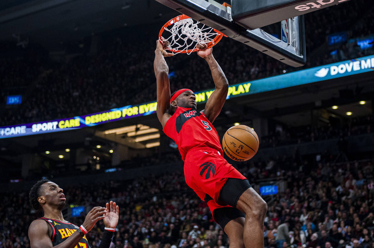 Toronto Raptors forward Precious Achiuwa hangs off the rim after dunking against the Atlanta Hawks ...