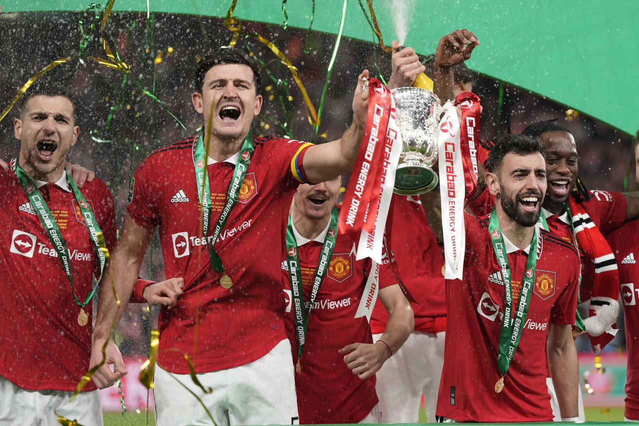 Manchester United's Bruno Fernandes, centre right, and Harry Maguire, second from left, hold the tr...