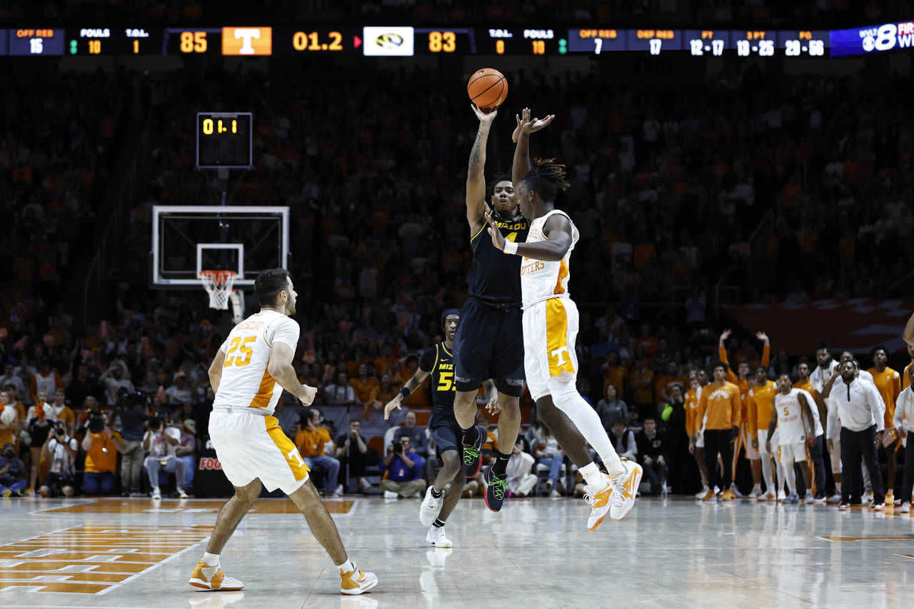 Missouri guard DeAndre Gholston (4) takes a last-second 3-point shot over Tennessee guard Jahmai Ma...