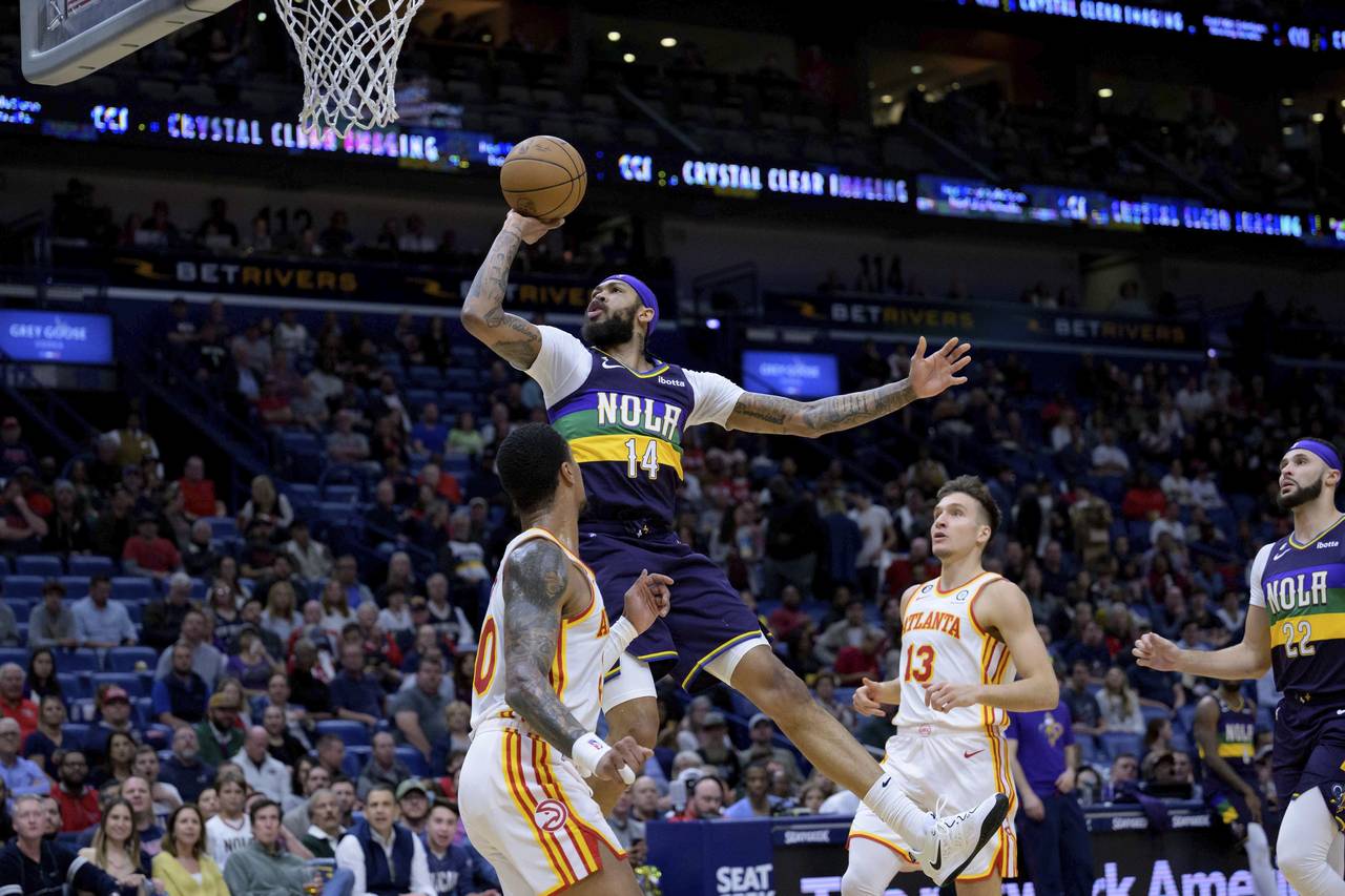 New Orleans Pelicans forward Brandon Ingram (14) shoots over Atlanta Hawks forward John Collins (20...