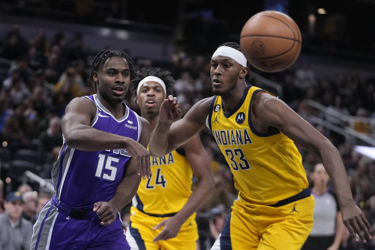 Sacramento Kings' Davion Mitchell (15) makes a pass against Indiana Pacers' Myles Turner (33) durin...