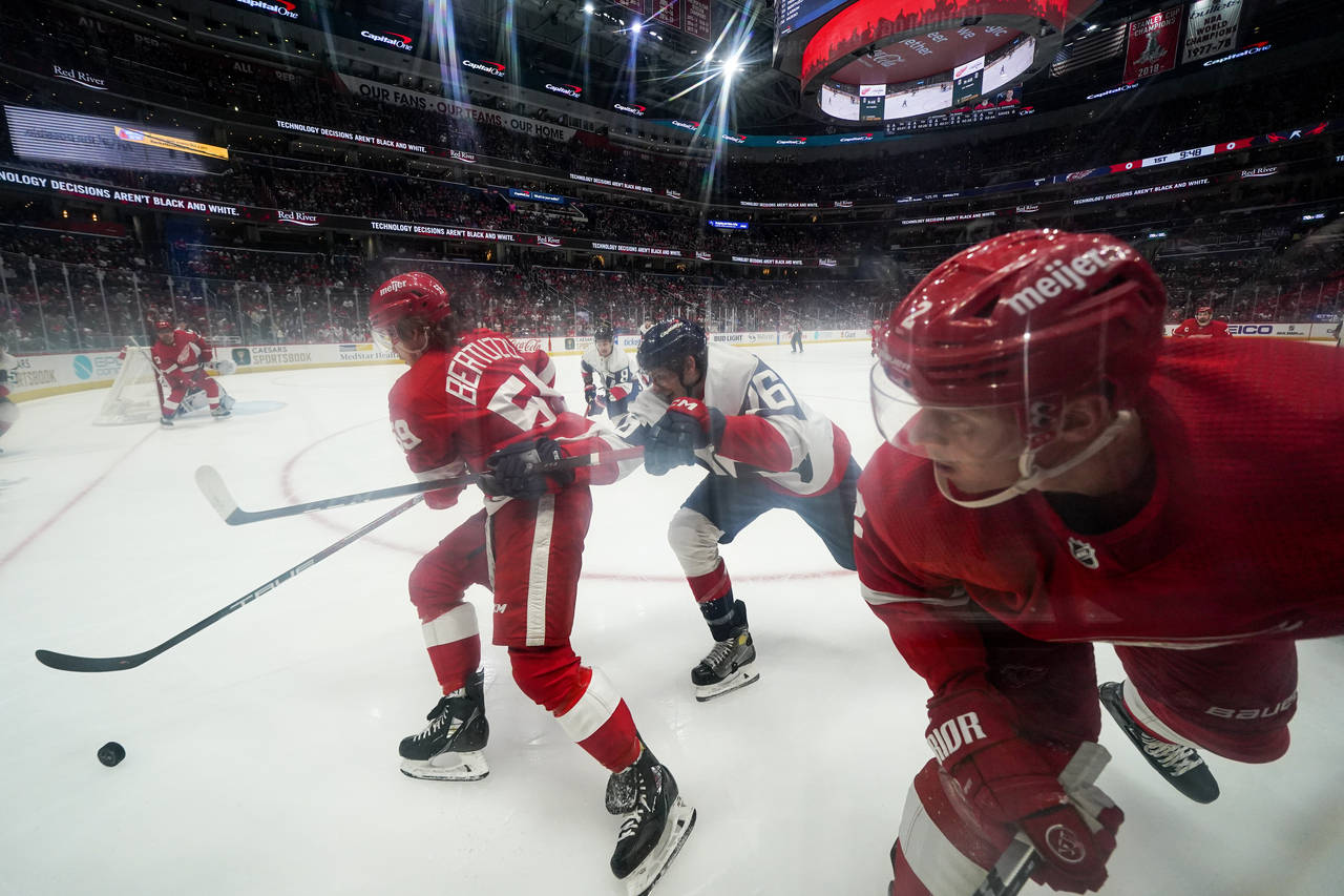 Detroit Red Wings left wing Tyler Bertuzzi, left, skates with the puck as Washington Capitals cente...