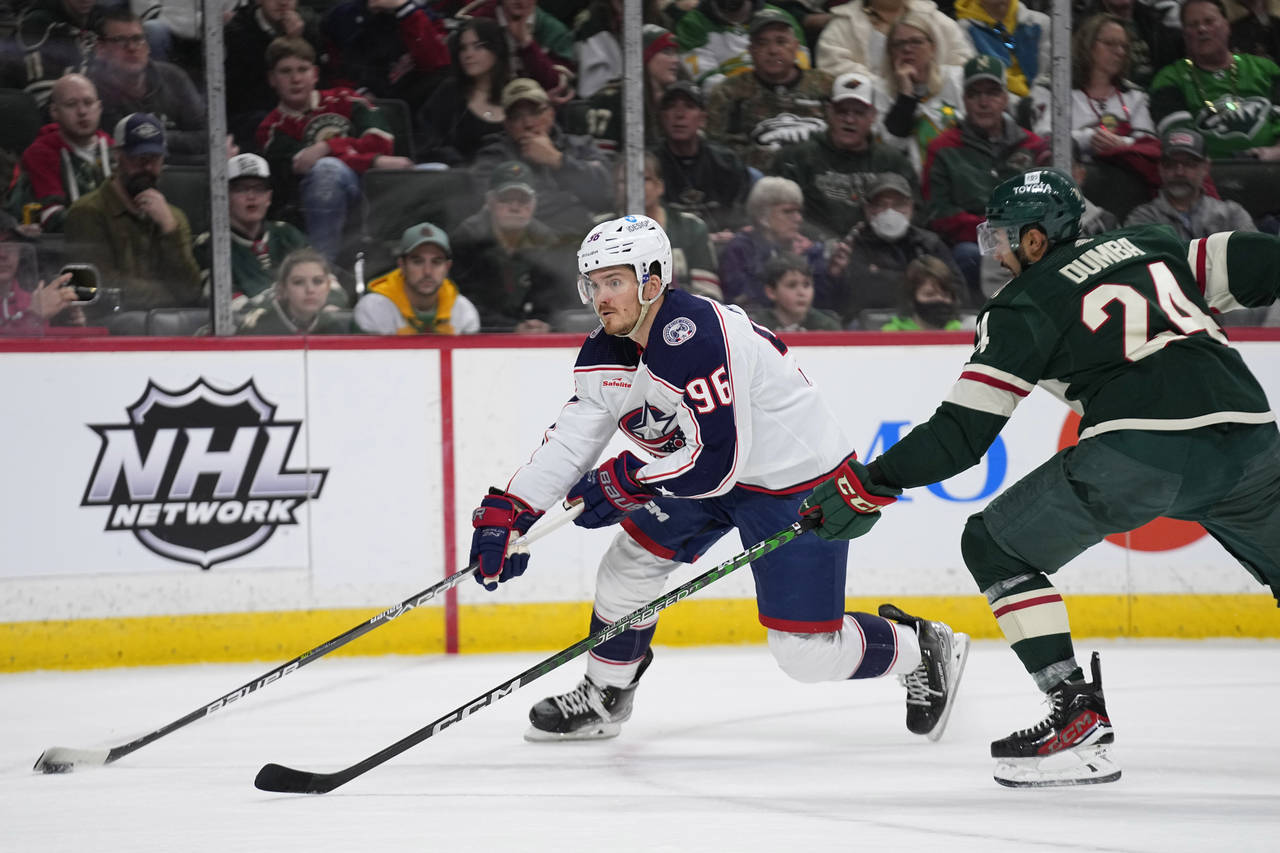 Columbus Blue Jackets center Jack Roslovic (96) skates with the puck against Minnesota Wild defense...