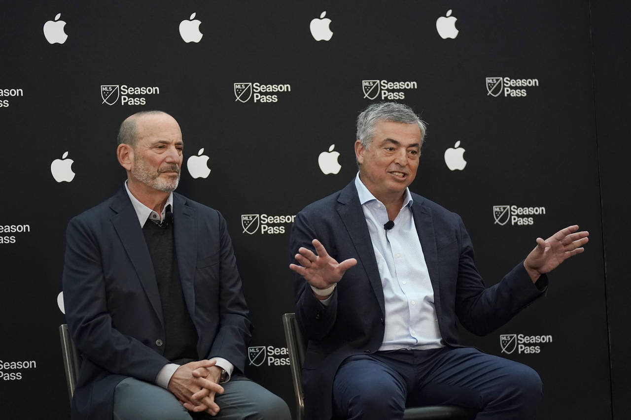 Apple senior vice president of services Eddy Cue, right, speaks next to Major League Soccer Commiss...