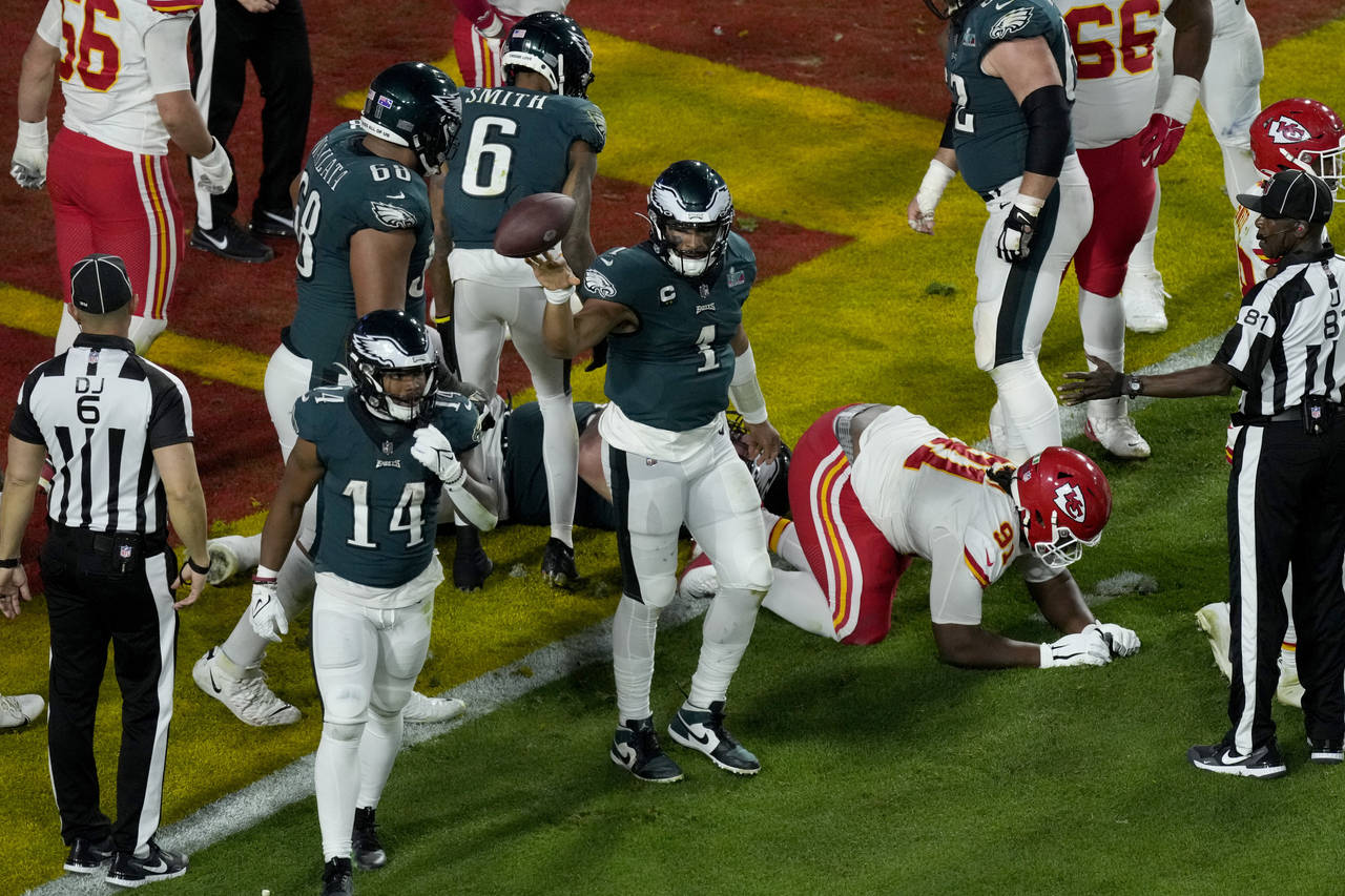Philadelphia Eagles quarterback Jalen Hurts (1) tosses the ball after his touchdown against the Kan...